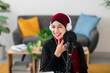 © Studio Marmellata/Stocksy - Cheerful Arab woman recording voice message on smartphone
