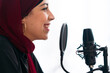 © Studio Marmellata/Stocksy - Smiling Arab woman recoding podcast and talking in mic