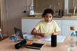 © BONNINSTUDIO/Stocksy - Hispanic girl asking question to smart speaker while doing homework