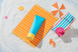 © Marc Tran/Stocksy - sunscreen products lying on papercut beach, skincare ads in top view angle