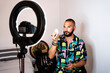 © Eloisa Ramos/Stocksy - Young stylist man putting on makeup looking at camera