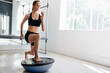 © Nicola Suttle/Stocksy - Serious sportswoman doing lunge exercise on bosu ball