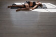© Nicola Suttle/Stocksy - Sportswoman stretching body on mat at home