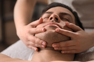 Wall Mural - Man receiving facial massage in beauty salon, closeup