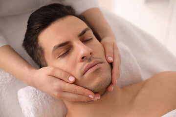 Wall Mural - Man receiving facial massage in beauty salon, above view