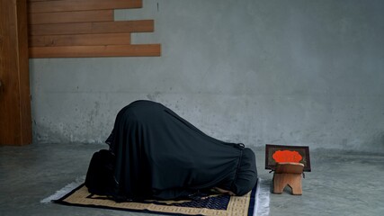 Wall Mural - Young Muslim woman praying at home