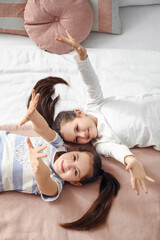 Poster - Cute twin girls lying on bed