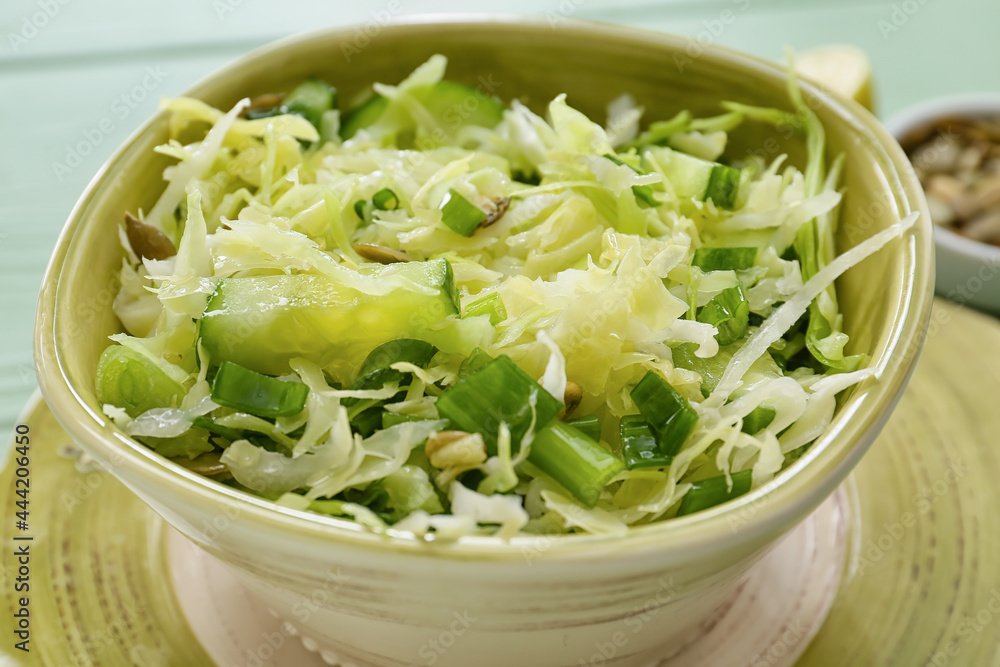 Bowl with tasty cabbage salad on table, closeup