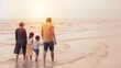 © feeling lucky - Rear view image of happy asian family dad and mom with their children boy and girl  walking together on sunrise beach during happy day