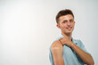 © skif - Happy Smiling Vaccinated Teenager Shows His Hand With A Patch After An Injection Of The Coronavirus Vaccine, Passing On A Light Background. Advertising Of Vaccination Against Coronavirus