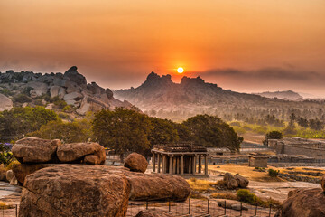 Wall Mural - Rocky mountain sunrise flares with dramatic sky at morning flat angle shot is taken at Hemakuta Hill, Hampi, Karnataka india.