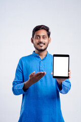 Wall Mural - Young indian man showing tablet over white background.