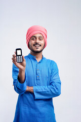 Wall Mural - Young indian farmer using mobile phone over white background.