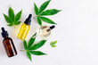 Bottles CBD oil,  and hemp leaves on white background with copy space. Oil with hemp oil and marijuana leaves