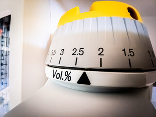 Sevoflurane inhalational anaesthetic's vaporizer concentration dial set between 2.5 and 2 Volume percents. Shallow depth of field.