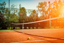 Wide Angle Photo Of Artificial Grass Tennis Court With Tennis Ball During Sunset. Competitive Individual Sports Concept.