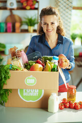 Wall Mural - happy modern female with food box in kitchen