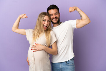 Young couple pregnant and doing strong gesture