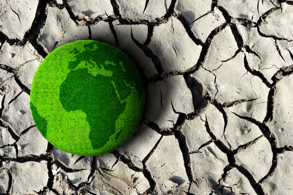 Green planet on the dry cracked soil. Concept of change climate or global warming. - obrazy, fototapety, plakaty 