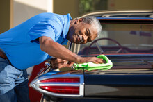 Older Man Drying Off Sport Sedan After Detailing 