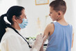 © Mediteraneo - Coronavirus vaccination. Covid-19 vaccine. Doctor vaccinating child. Little boy getting flu shot.