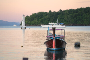 Longtail boat mooring in the tropical sea at sunset background. Luxury Sailing theme.