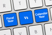 Fiscal Year Vs. Calendar Year - Inscription On Blue Keyboard Key.