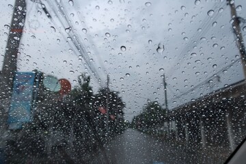 Wall Mural - Abstract raindrops on car windshield, sky background, rainy season, images for nature background, selectable focus.