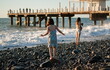 © gmstockstudio - Mother with child girl at the sea beach on sunset