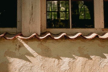 Wall Mural - An old window in an old building of the last century. shadows from windowsill on wall. orange yellow painted wall