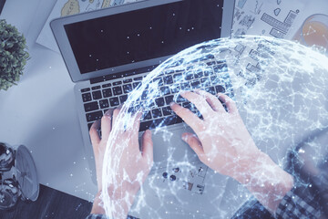 Double exposure of man's hands typing over computer keyboard and social network theme hologram drawing. Top view. People connection web concept.