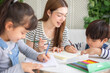 © anon - happy loving family. pretty young mother reading a book and drawing to her daughter and son.Mother teach Asian preschool student do homework by reawing by a color.