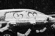 Lovely weather. Blurry falling snowflakes. Two hearts love symbol over snow covered car during snowfall. Paris, France. Romantic urban background. Black white historic photography.
