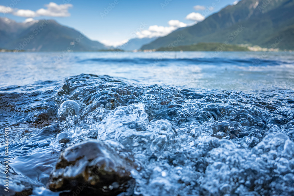 Wellen auf dem Comer See vor bewaldeten Berghängen