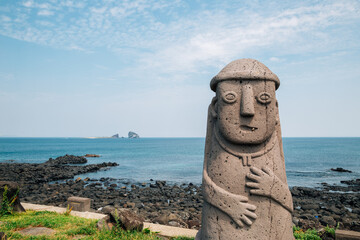 Canvas Print - Dol hareubang stone grandpa sculpture and sea, Jeju Olle Trail in Jeju Island, Korea