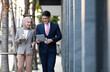 © NVB Stocker - Young business muslim woman and business man colleague walking and discussing outside the office. Woman is holding a coffee and businessman is holding a digital tablet outdoor.