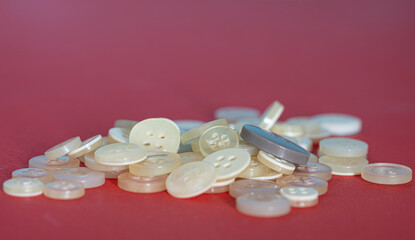 Buttons of different sizes and shades of whites. Selective focus points. Blurred background