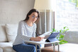 © ty - Smiling girl sit on couch watching webinar on laptop. Happy young woman study on online distant course.