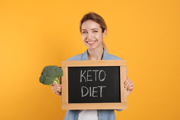 Canvas Print - Woman holding blackboard with phrase Keto Diet and broccoli on yellow background