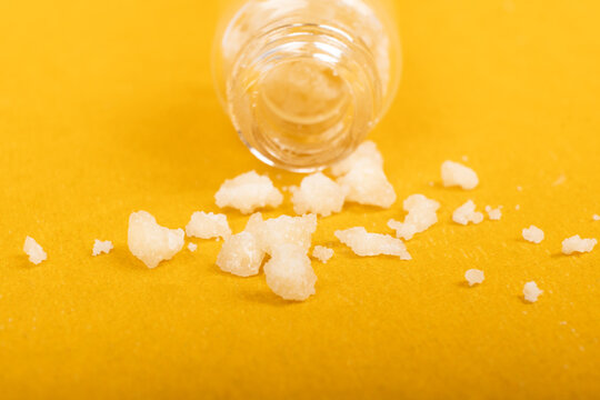 crystal mephedrone designer drugs, bath salt on yellow background.