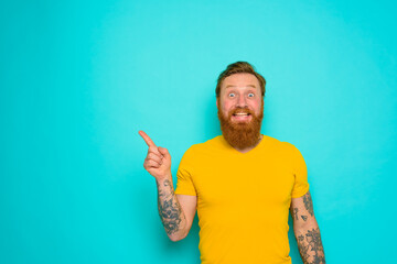 Wall Mural - Man with yellow t-shirt and beard is shocked about something