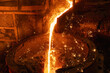 Liquid cast iron is poured into the ladle in a thin stream. Lots of sparks.