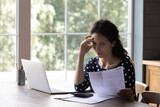 Fototapeta  - Concern housewife checking utility bill, seeing mistaken too high costs. Worried woman reading paper invoice with doubt, having problems with loan, mortgage, taxes fee payment. Personal budget concept