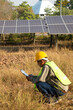 Male engineer holding notebook and work record to inspect solar system. Outdoor. Concept of electric power technology industry.