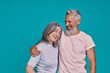 © gstockstudio - Happy senior couple smiling while standing together against blue background