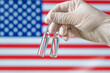 bottle with American vaccine for coronavirus close-up. Concept of treatment, clinical trial, distribution and research due to corona virus pandemic. COVID-19 vaccine on USA flag background,