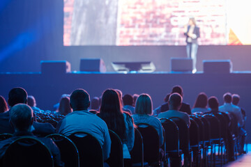 Audience listening to speaker in neon light