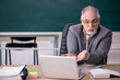 © Elnur - Old male teacher in front of blackboard in telestudy concept