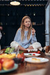 © undrey - Girl eats vegetables sitting on the kitchen table.