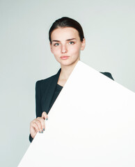 young pretty brunette girl with placard shit copyspace on white background wearing business costume student